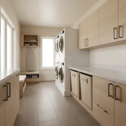 Modern laundry room with light wood cabinets stacked white washing machines window and ironing board