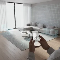 Person using phone to scan living room with grey sofa and blue furniture layout grid
