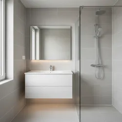 Modern bathroom with white floating vanity, rectangular mirror, glass shower divider, and grey wall tiles