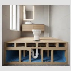 Bathroom interior view showing toilet plumbing under wooden floor with blue ground cover and bathroom vanity