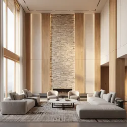 Large living room with a tall stone wall, wood panels, grey sofas, and round table
