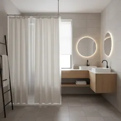 Modern bathroom with double sinks wooden cabinet round backlit mirrors and a beige shower curtain