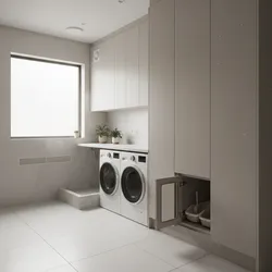 Modern laundry room with washing machines white cabinets window and a pet litter box station