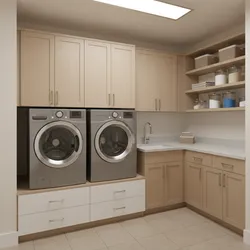 Modern laundry room with silver washer and dryer under light wood cabinets and small sink