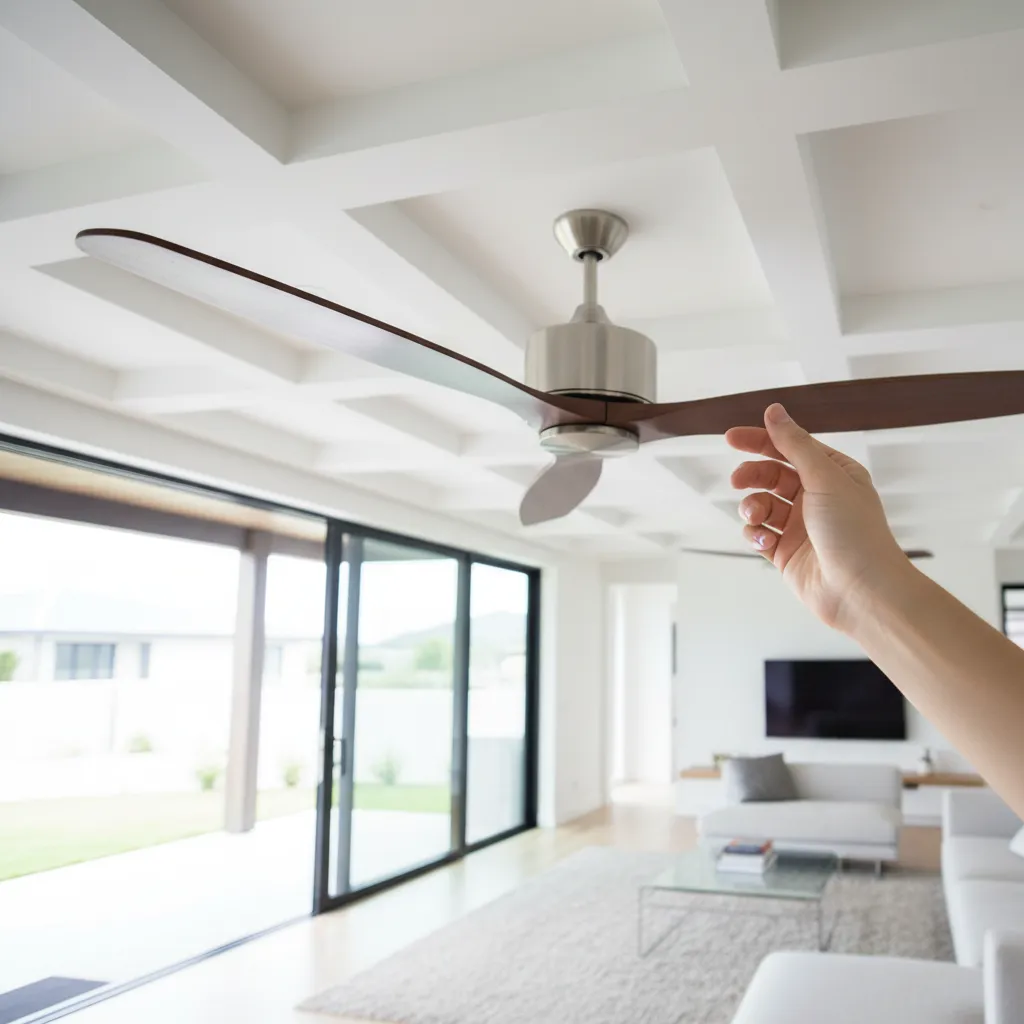 Hand spinning ceiling fan blade to test bearing smoothness