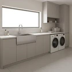 Modern minimalist laundry room with grey cabinets stainless steel sink white washing machines and window