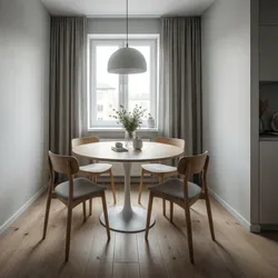Small dining area featuring round white table four wooden chairs grey curtains and ceiling light