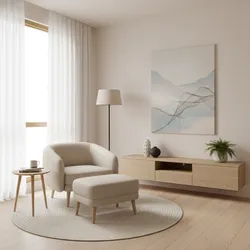Minimalist living room corner with cream armchair, footrest, wooden cabinet, floor lamp, and wall art